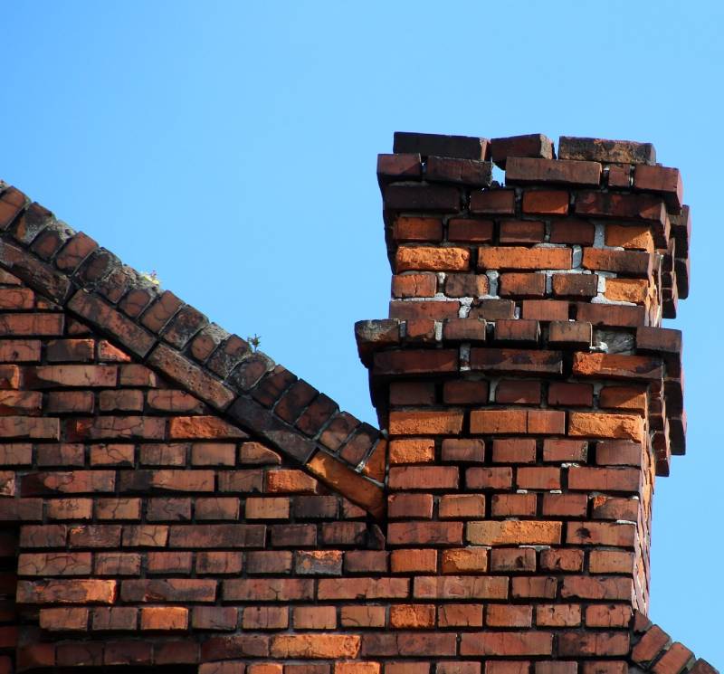 Damaged chimney on an Maybee home showing cracks and missing mortar